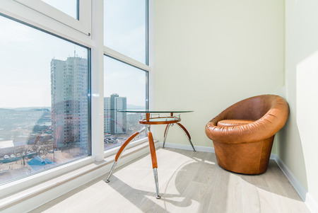The photo of a bright balcony with a chair and a tableの写真素材
