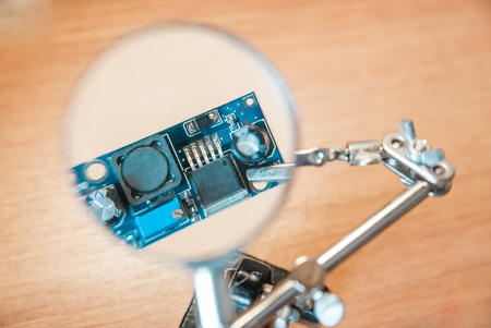 The photo of the electric circuit because of magnifying glass close upの写真素材