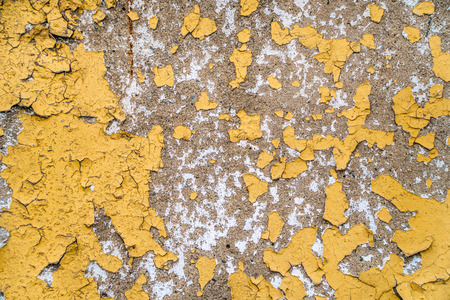 Texture of the old painted yellow wall with the cracked paint
