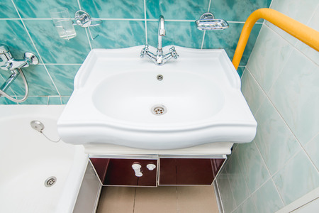 The photo of a white clean sink with the crane in the bathroomの写真素材