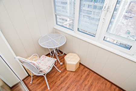 The photo of a bright balcony with a chair and a tableの写真素材