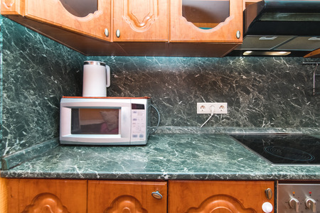 The photo of completely equipped light kitchen with household appliancesの写真素材
