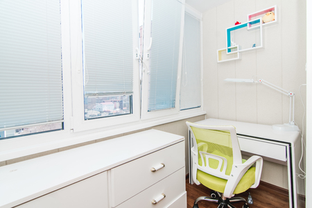 The photo of bright home office with a table, a chair and a lamp on a balconyの写真素材
