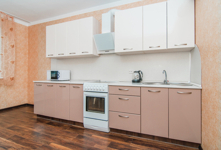 The photo of completely equipped light kitchen with household appliancesの写真素材