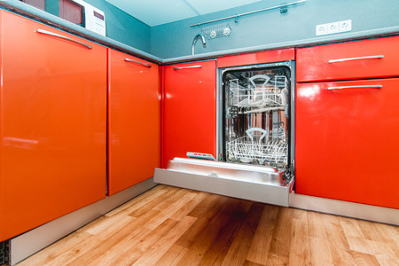 The photo of the built-in dishwasher in kitchen of orange colorの写真素材
