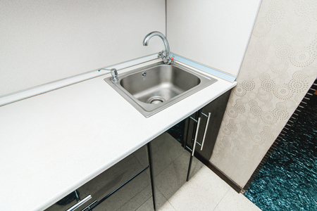 The photo of a white clean sink with the crane in the kitchenの写真素材