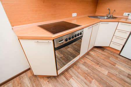 The photo of completely equipped light kitchen with household appliancesの写真素材