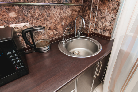 The photo of a white clean sink with the crane in the kitchenの写真素材
