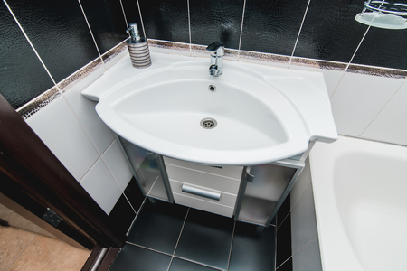 The photo of a white clean sink with the crane in the bathroomの写真素材