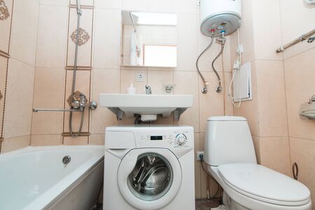The photo of the light  bathroom with household appliances