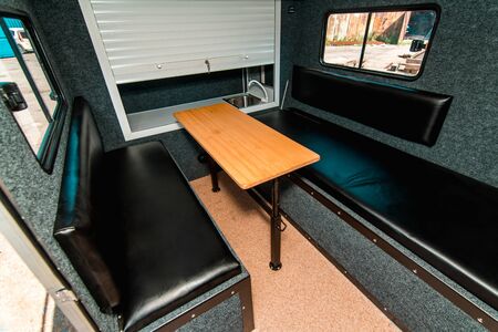 Photo of a small room with table, leather chairs and windowの写真素材