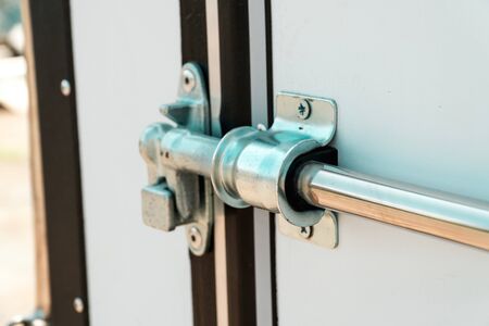Photo of metal chromeplated the lock on a white door of the van close up