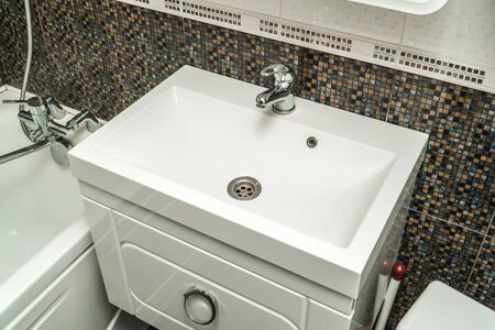 The photo of a white clean sink with the crane in the bathroomの写真素材
