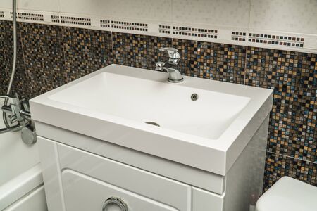 The photo of a white clean sink with the crane in the bathroomの写真素材