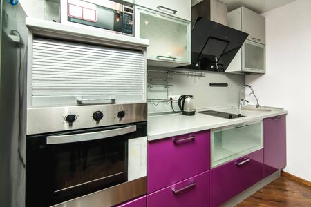 The photo of completely equipped light kitchen with household appliancesの写真素材