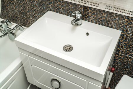 The photo of a white clean sink with the crane in the bathroomの写真素材
