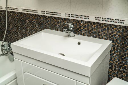The photo of a white clean sink with the crane in the bathroomの写真素材