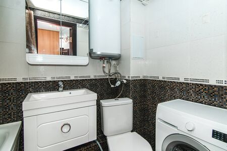 The photo of the light white bathroom with household appliancesの写真素材