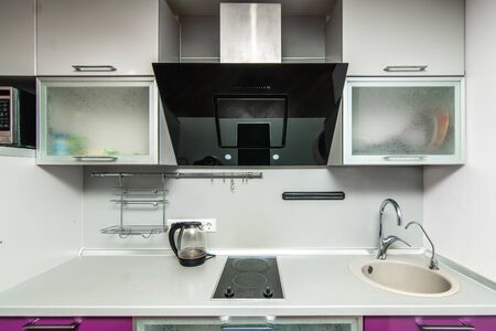 The photo of completely equipped light kitchen with household appliancesの写真素材