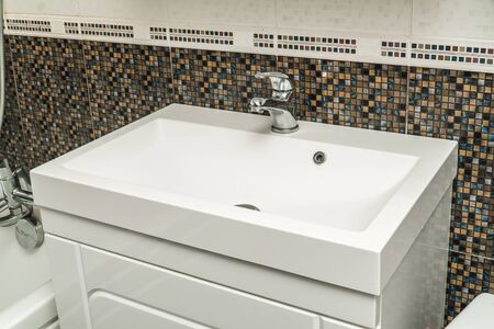 The photo of a white clean sink with the crane in the bathroomの写真素材