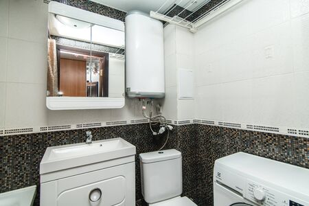 The photo of the light white bathroom with household appliancesの写真素材
