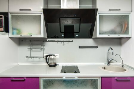 The photo of completely equipped light kitchen with household appliancesの写真素材