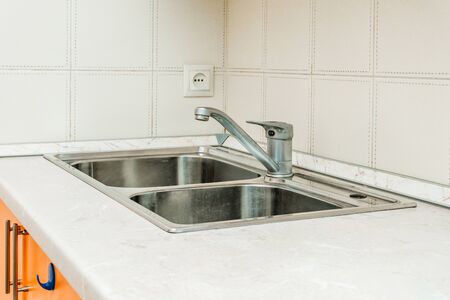 The photo of a white clean sink with the crane in the kitchenの写真素材