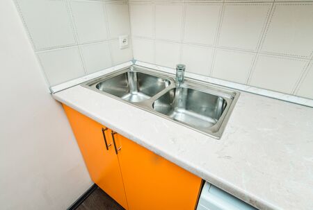 The photo of a white clean sink with the crane in the kitchenの写真素材