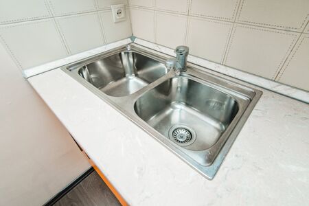 The photo of a white clean sink with the crane in the kitchenの写真素材