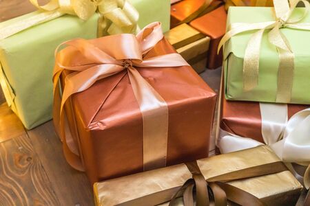 Decorated boxes with New Year gifts tied with ribbons lying under the tree.の写真素材