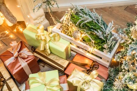 Decorated boxes with New Year gifts tied with ribbons lying under the tree.の写真素材