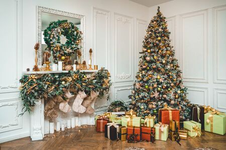 New Year 's Eve decorated with toys green tree with gifts standing with fireplaces on which weigh socksの写真素材