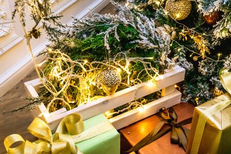 Decorated boxes with New Year gifts tied with ribbons lying under the tree.の写真素材