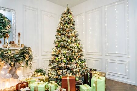 Decorated boxes with New Year gifts tied with ribbons lying under the tree.の写真素材