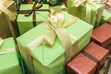 Decorated boxes with New Year gifts tied with ribbons lying under the tree.の写真素材