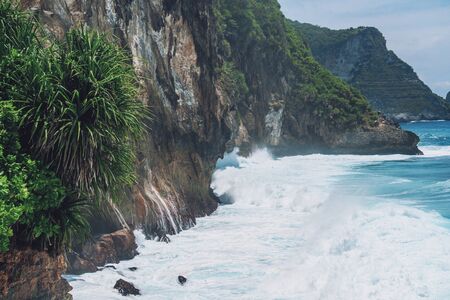 Photo of large waves crashing into large rocks on Nusa Penida island in Indonesiaの写真素材