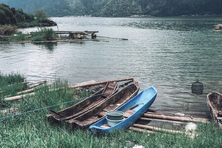 Photograph of old fisherman boats standing on the bank by the riverの写真素材