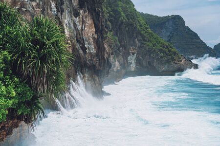 Photo of large waves crashing into large rocks on Nusa Penida island in Indonesiaの写真素材