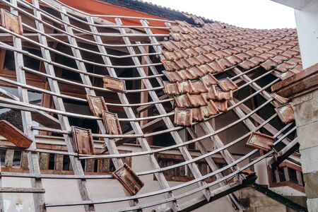 bright photo of abandoned building with broken red cipher roofの写真素材