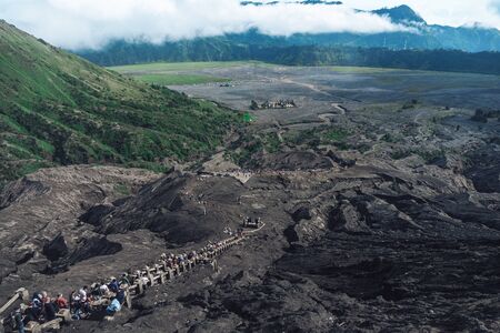 Photograph of rocks with volcanic rock and people climbing stairs on Java Island in Indonesia