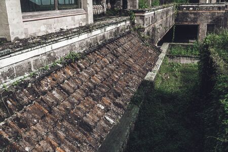 Dark photo of abandoned building with dirty walls and broken roof