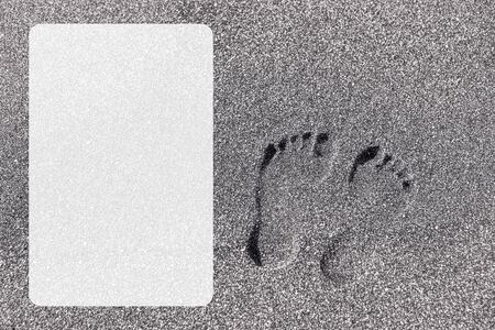 Photo of a man's leg on yellow sea sand close-up on a sunny day with a white text frameの写真素材