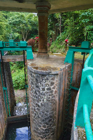 Photo of an old water dam for water supply to rice fields in Indonesia with water tapの写真素材