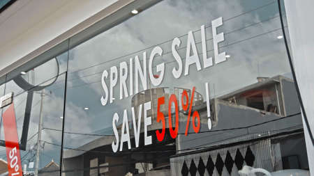 White and red text on a glass window with the inscription spring sale save 50の写真素材