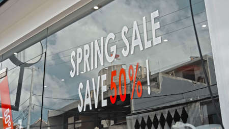 White and red text on a glass window with the inscription spring sale save 50の写真素材