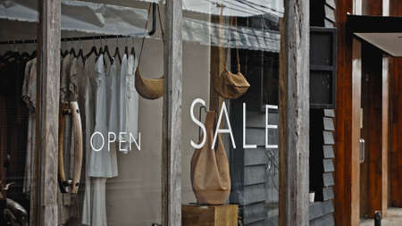 White text on the glass window of the store with the inscription saleの写真素材