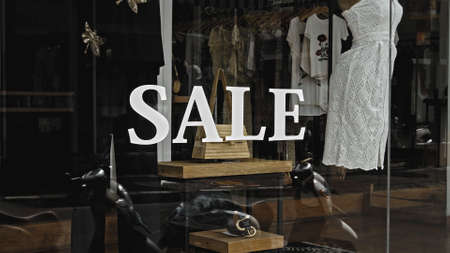 White text on the glass window of the store with the inscription saleの写真素材