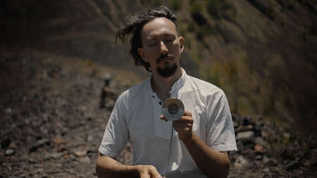A young Asian guy playing Tibedt singing copper cups on a viewing mountain in natureの写真素材