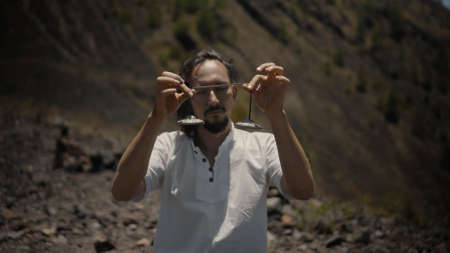 A young Asian guy playing Tibedt singing copper cups on a viewing mountain in natureの写真素材