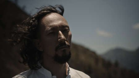 A young Asian guy playing Tibedt singing copper cups on a viewing mountain in natureの写真素材